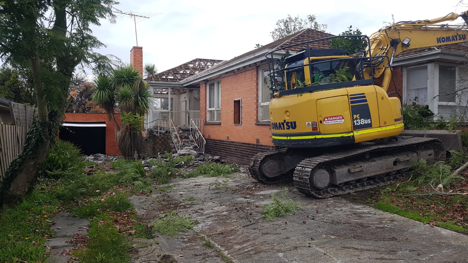 Excavator demolishing a brick house in Melbourne