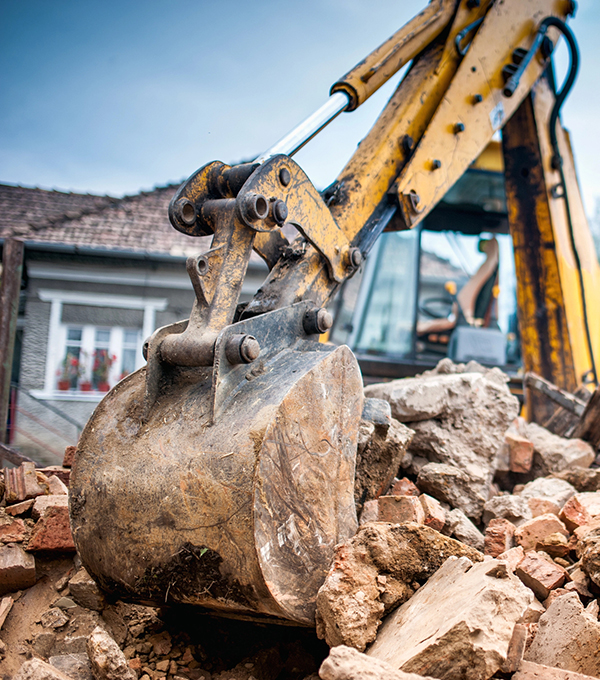 Excavator removing brickwork during a house demolition